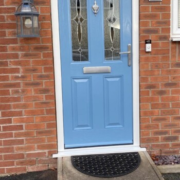 A blue door with glass and a black metal handle.