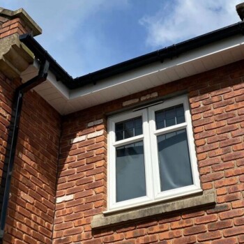 A brick building with a window and a roof.