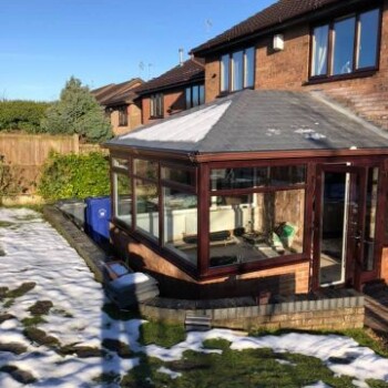 A house with snow on the ground and a patio.