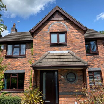 A brick house with a clock on the front of it.