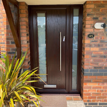 A brown door with glass and metal handles.