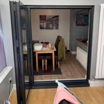 A person is standing in the doorway of an open room.