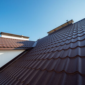 A brown roof with a white wall and two windows