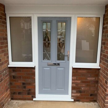 A grey door with two windows and a white frame.