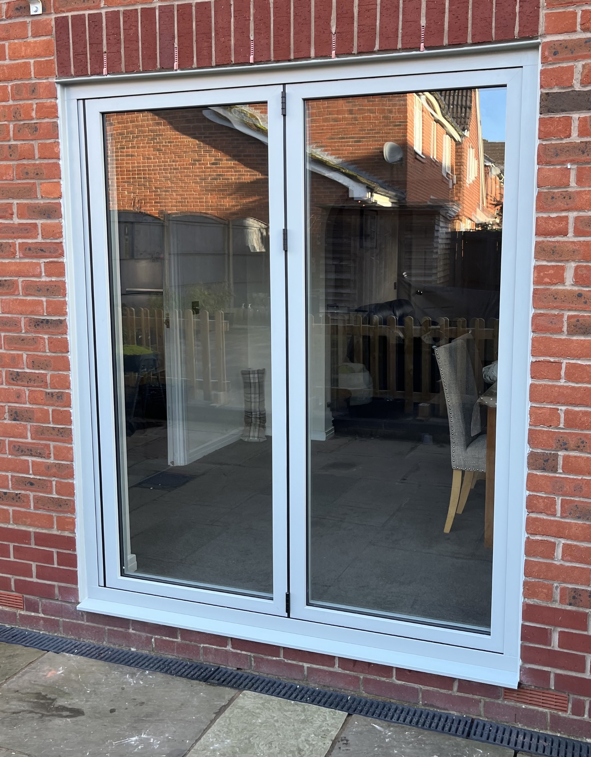 Glass patio doors on red brick wall.