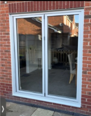 White sliding patio door on brick wall.
