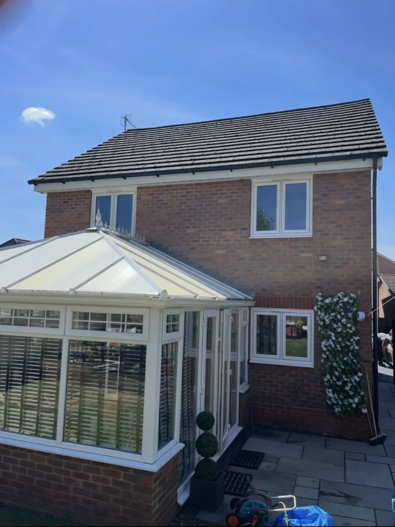 Brick house with a white conservatory.